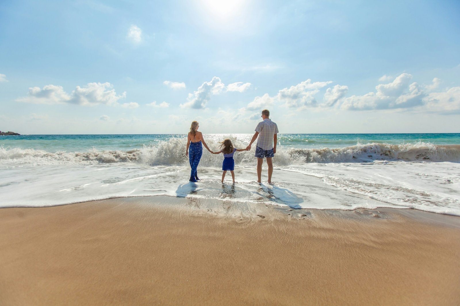Best Affordable Beach Holidays in Europe for 2024 1 man, woman and child holding hands on seashore